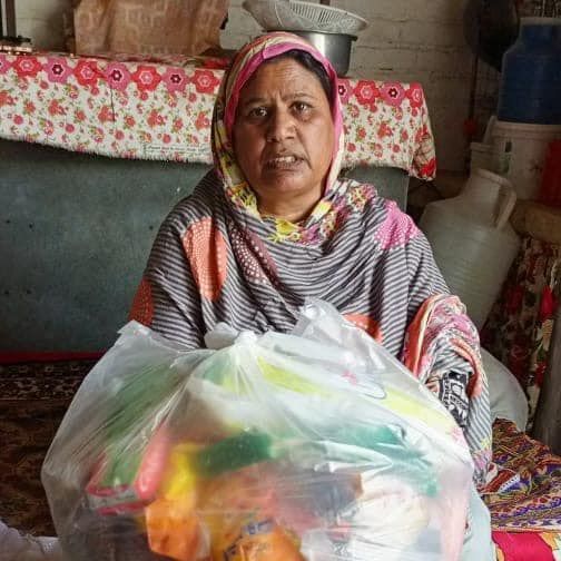 lady holding and sitting behind a large clear sack of food