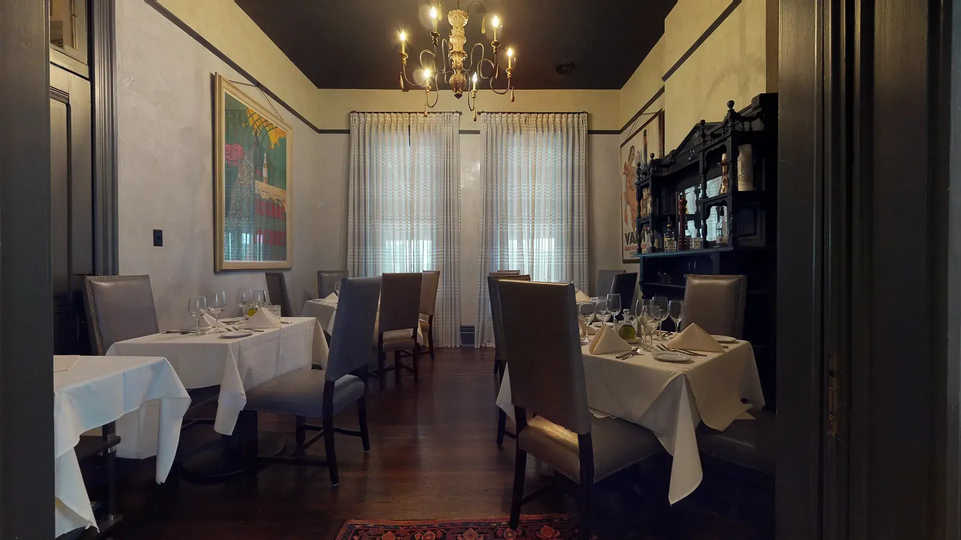 A dining room with tables and chairs and a chandelier