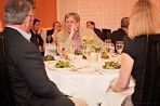 A group of people are sitting at a table with plates of food and wine glasses.