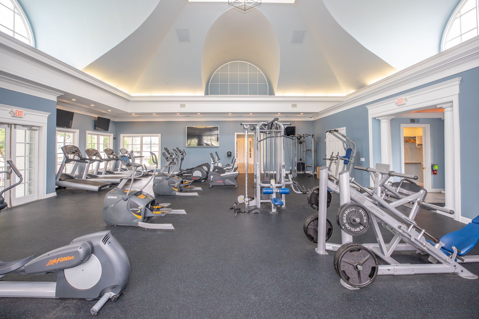 Bright gym interior with exercise machines, treadmills, and weight equipment under a vaulted ceiling at Quarry Apartments for Rent in Columbus, OH.