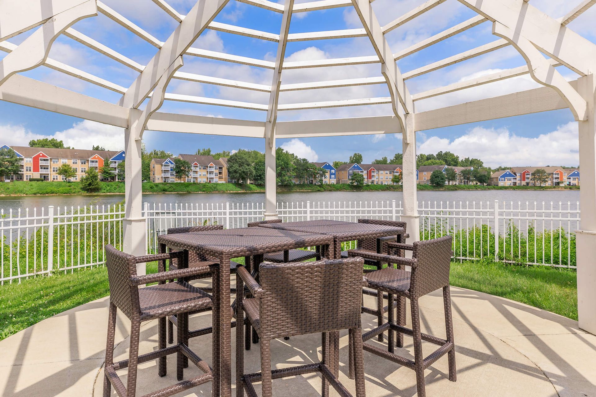 Patio gazebo with wicker table and chairs overlooking a waterfront neighborhood at Quarry Apartments for Rent in Columbus, OH.