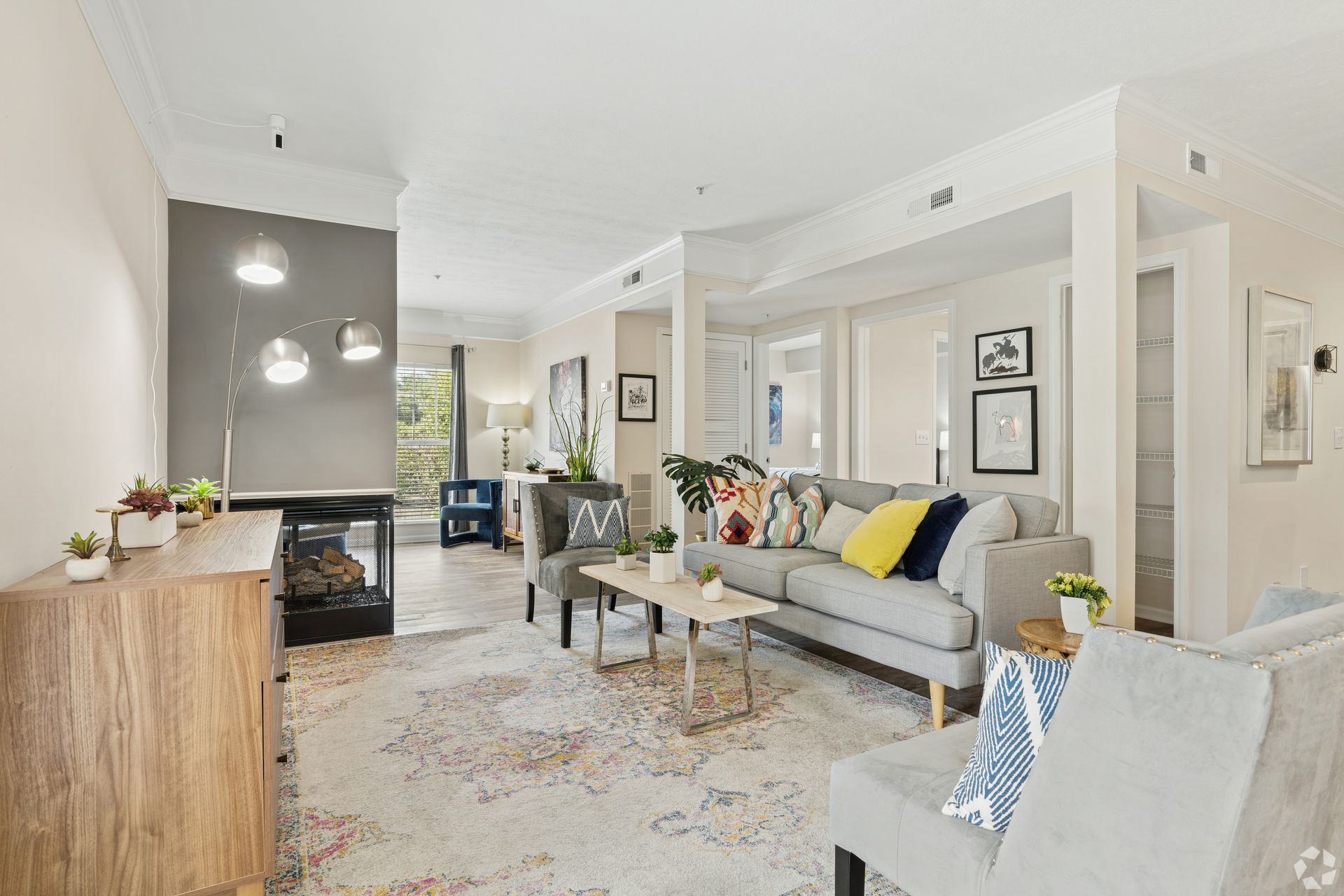 Bright modern living room with gray sofa, patterned rug, coffee table, and fireplace at Quarry Apartments for Rent in Columbus, OH.