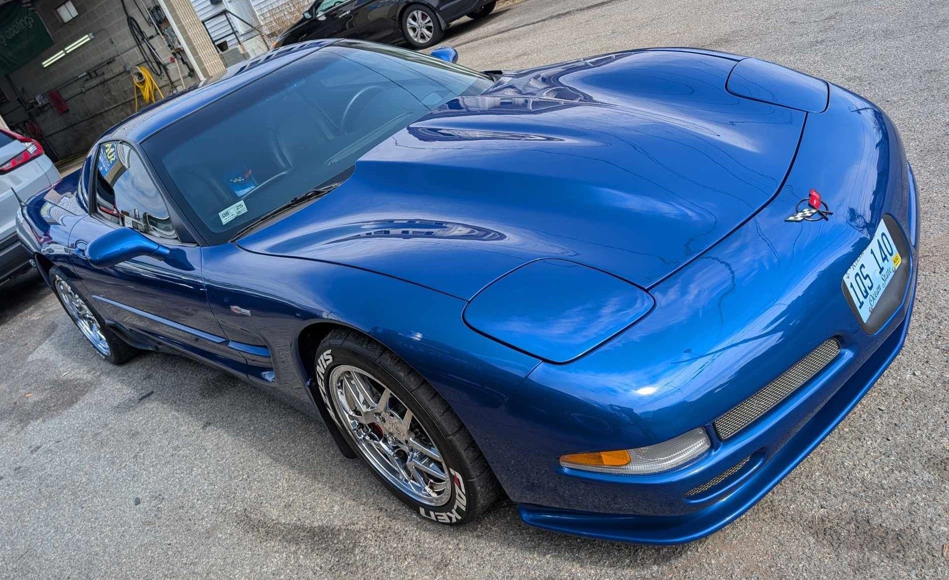 A blue C5 Chevrolet Corvette parked on an asphalt lot.