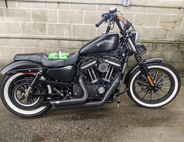 A black harley davidson motorcycle is parked in front of a brick wall