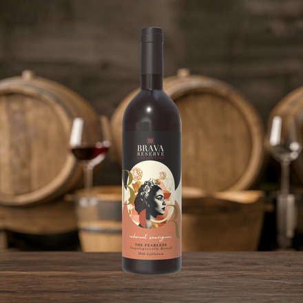 Wine bottle with illustrated label on a wooden table, barrels and wine glasses blurred in the background