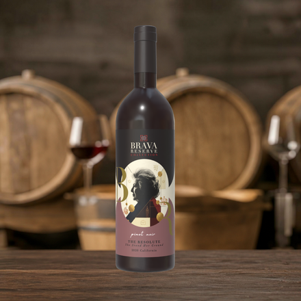 Brava wine bottle centered on a wooden table with barrels and glasses in the background