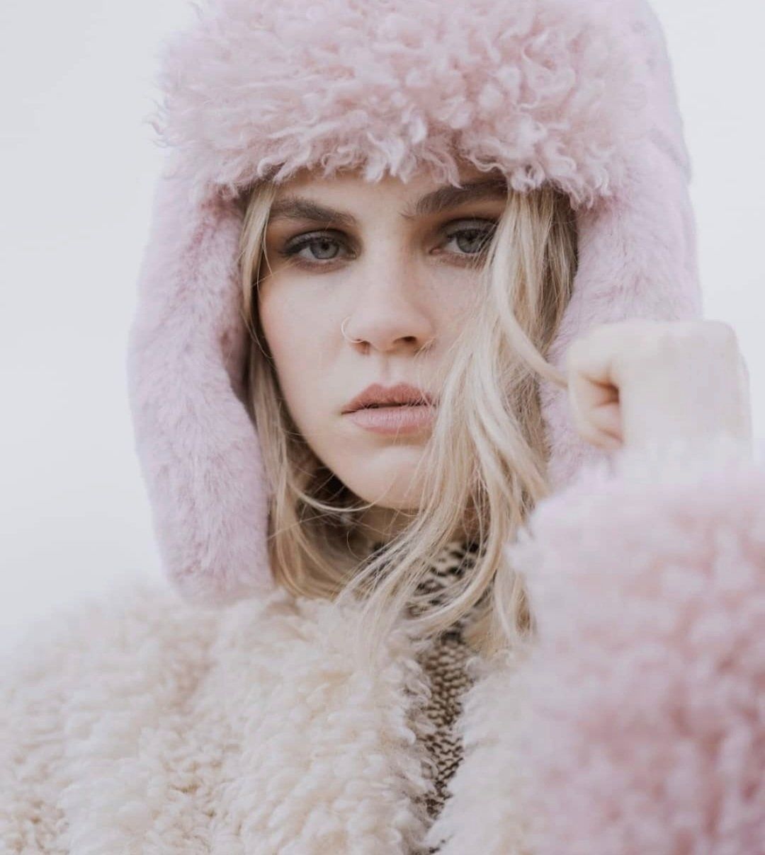 Pale woman wearing pink fluffy hooded jumper