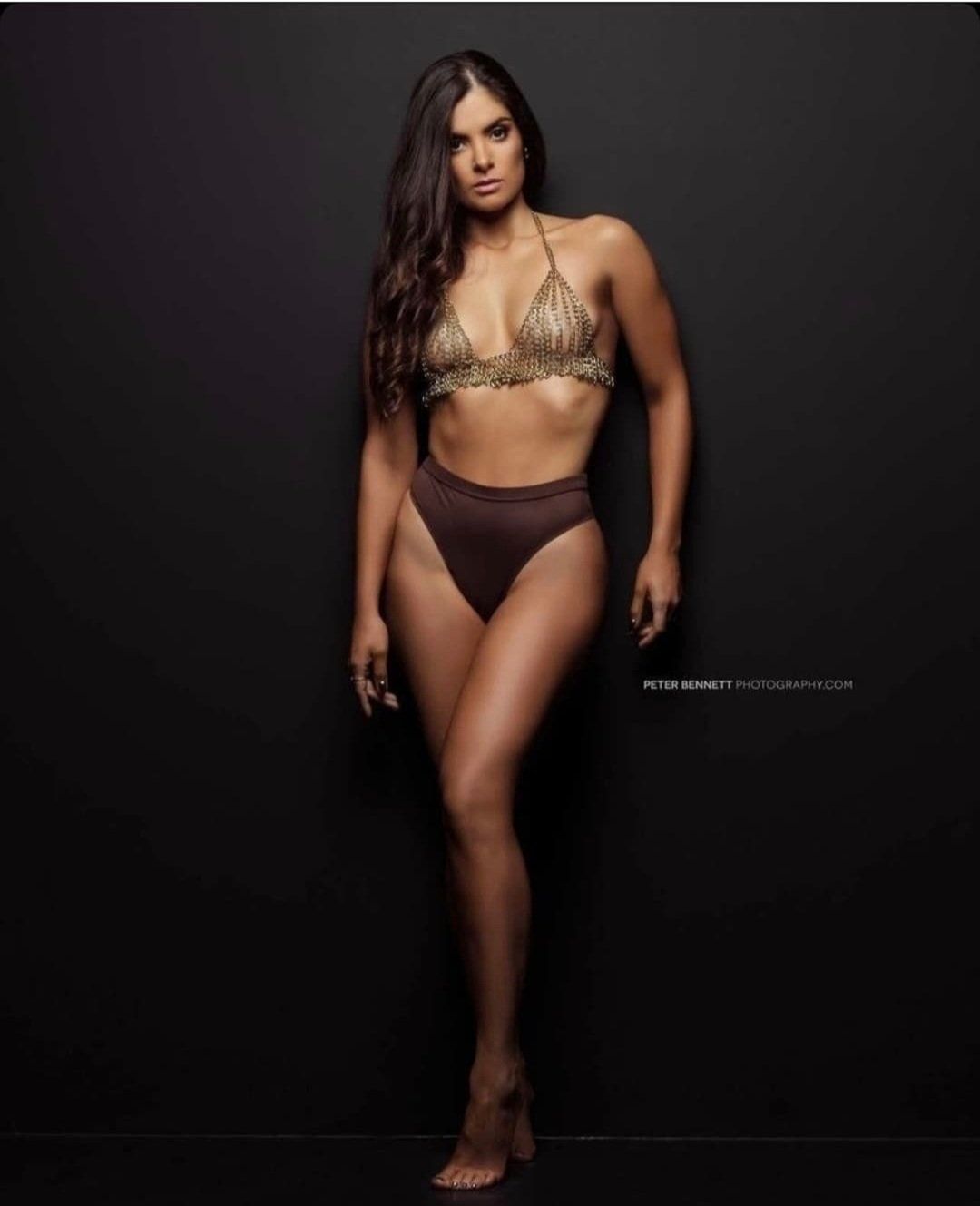 Woman in front of dark background wearing lingerie