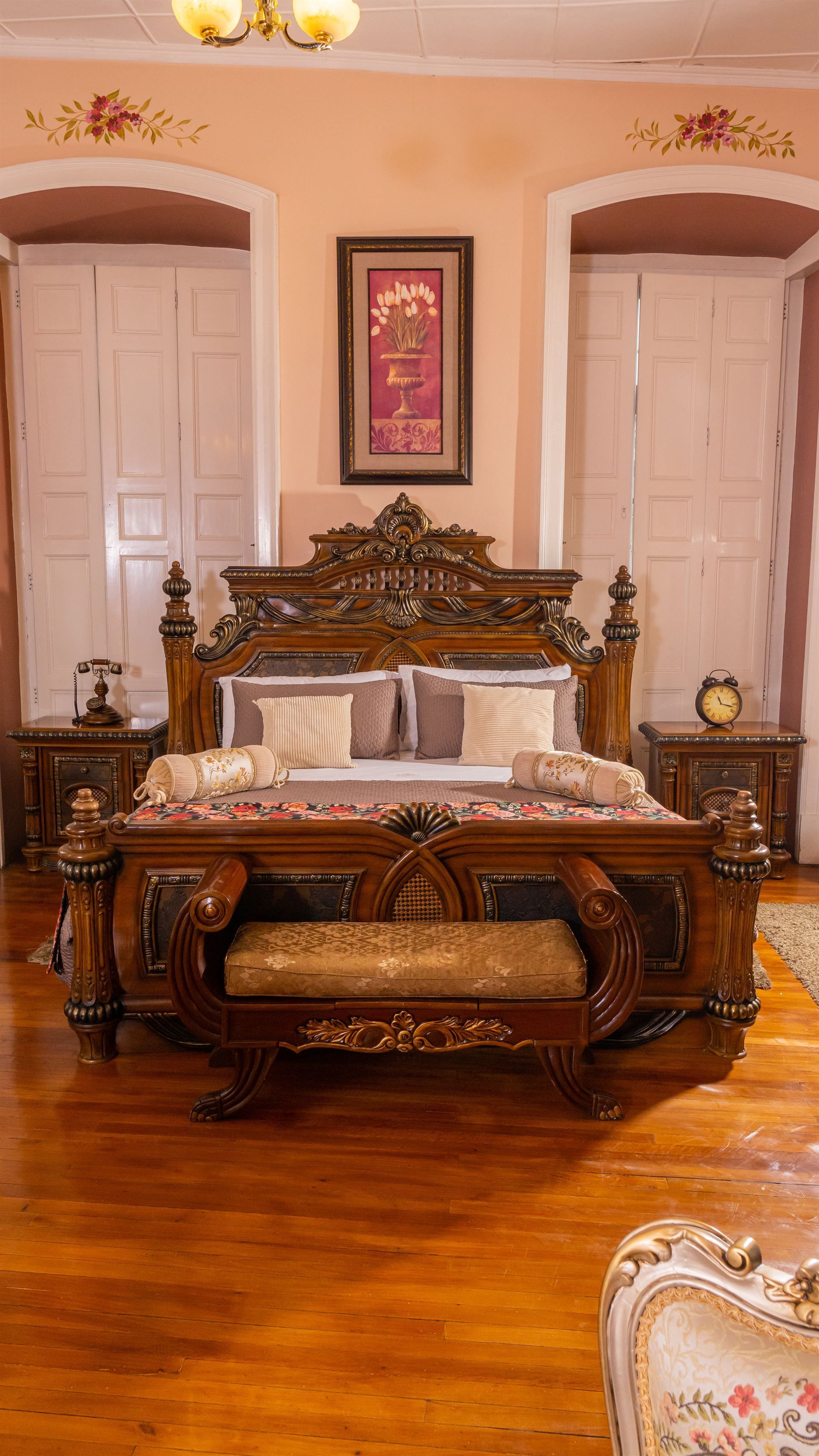 A colonial bedroom with a large bed and a bench.
