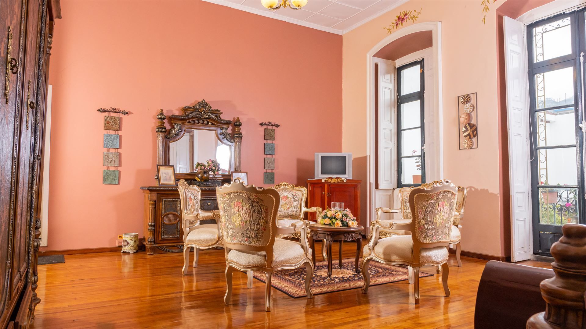 A living room with a table and chairs and a television.