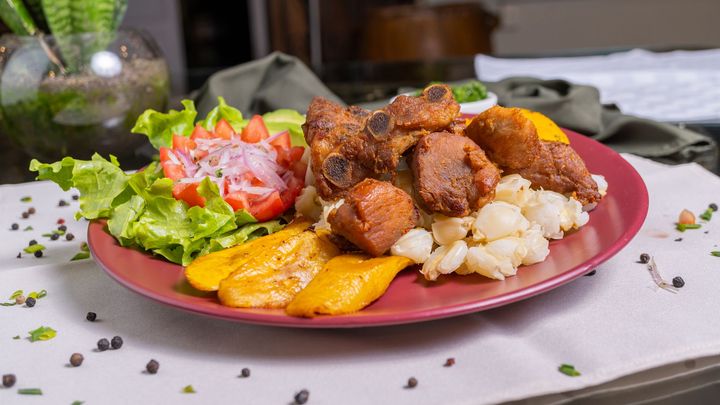 A plate of food with meat and vegetables on a table.