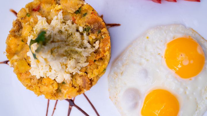 A plate of food with eggs and rice on a table.