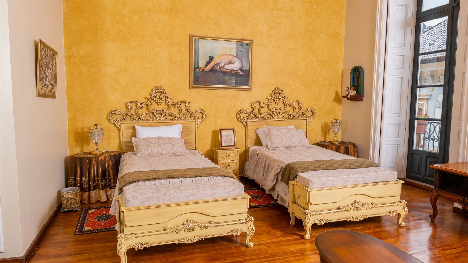 A bedroom with two beds and a painting on the wall.