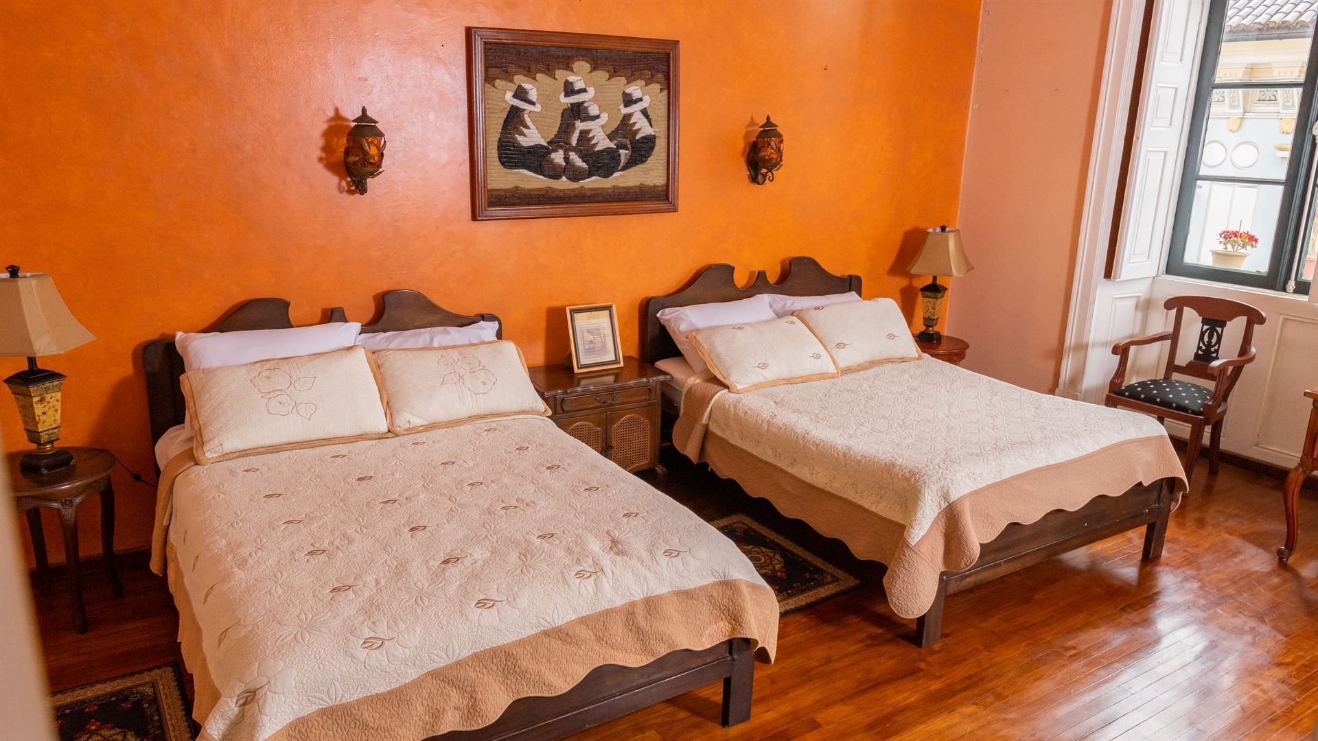 A bedroom with two beds and a painting on the wall.