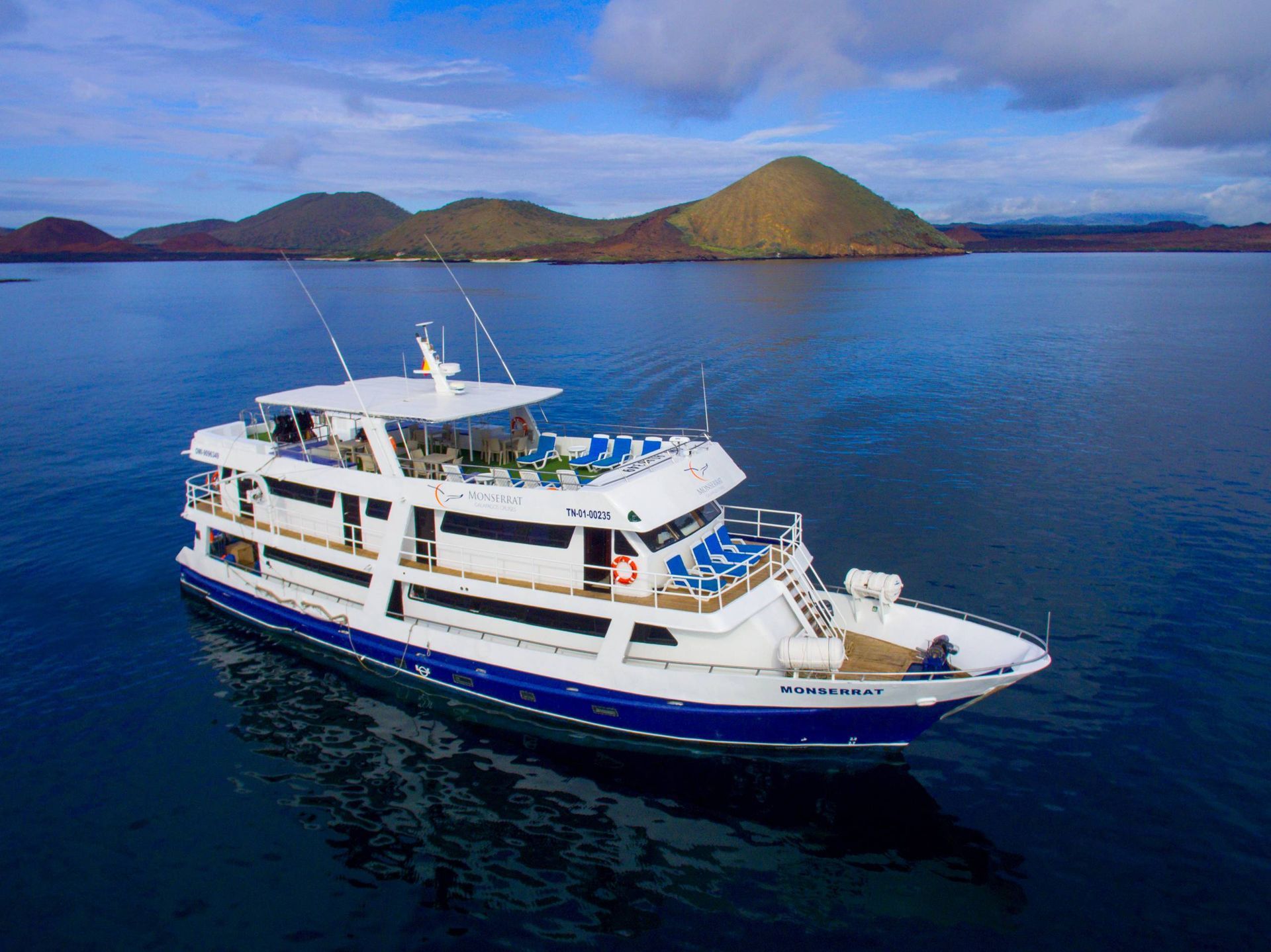 A large white and blue boat is floating on top of a body of water.