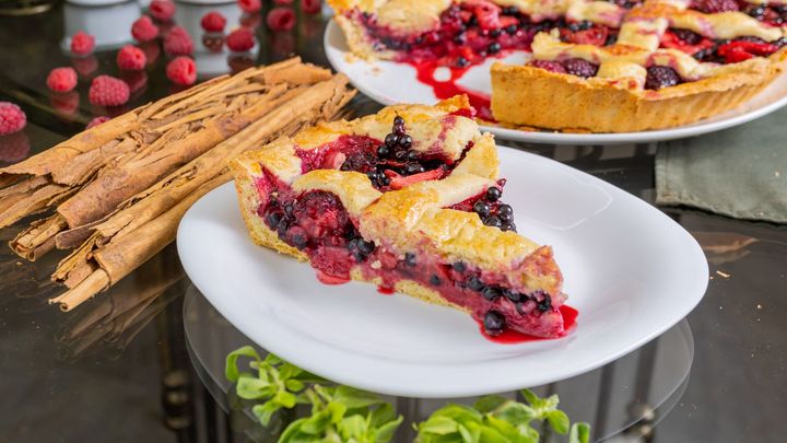 A slice of berry pie is on a white plate.