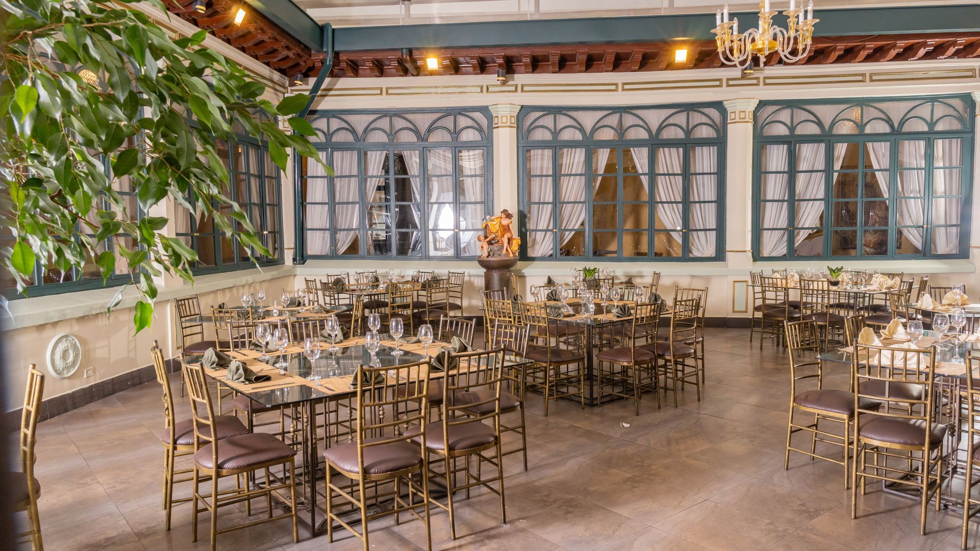 A large dining room with tables and chairs and a chandelier.