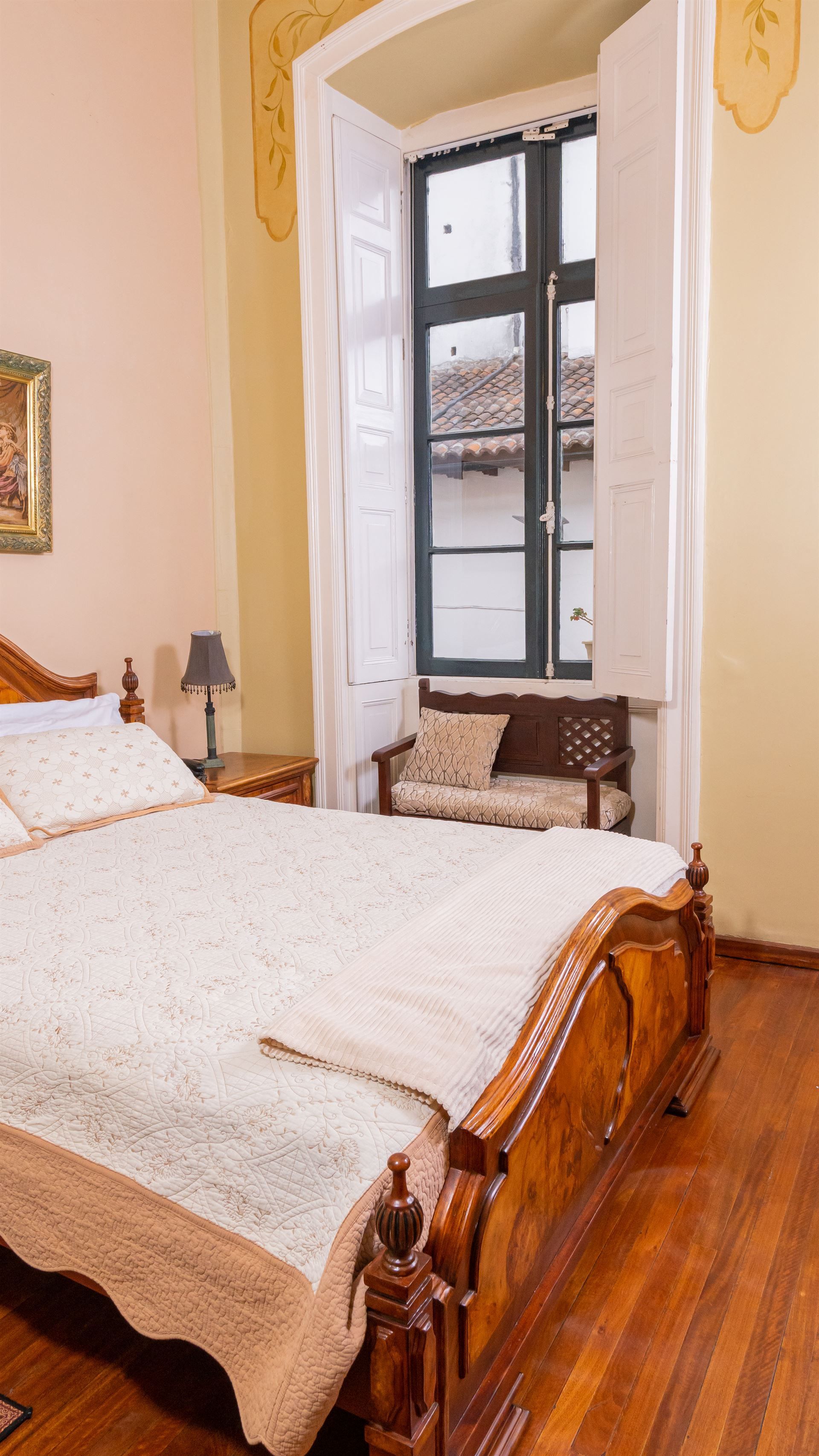 A bedroom with a large bed and a window.