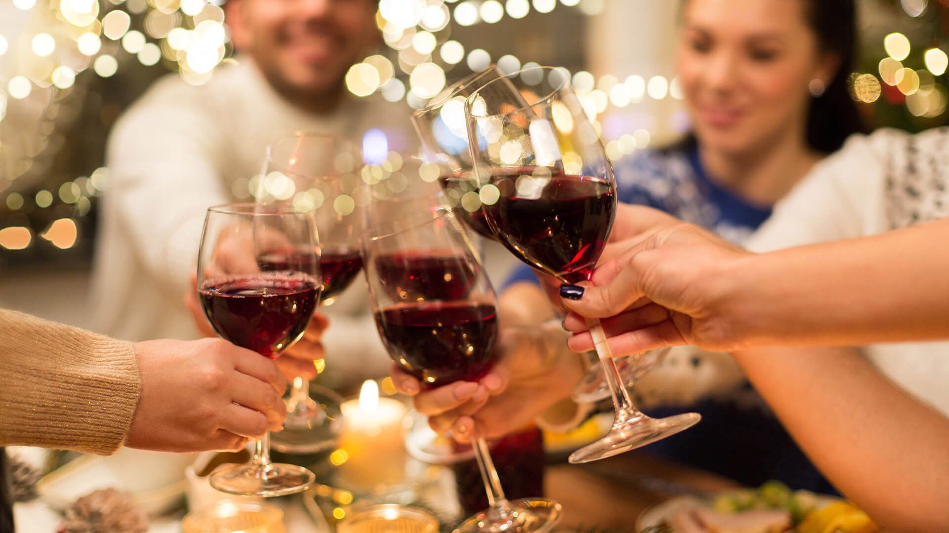 A group of people are toasting with wine glasses at a  party.