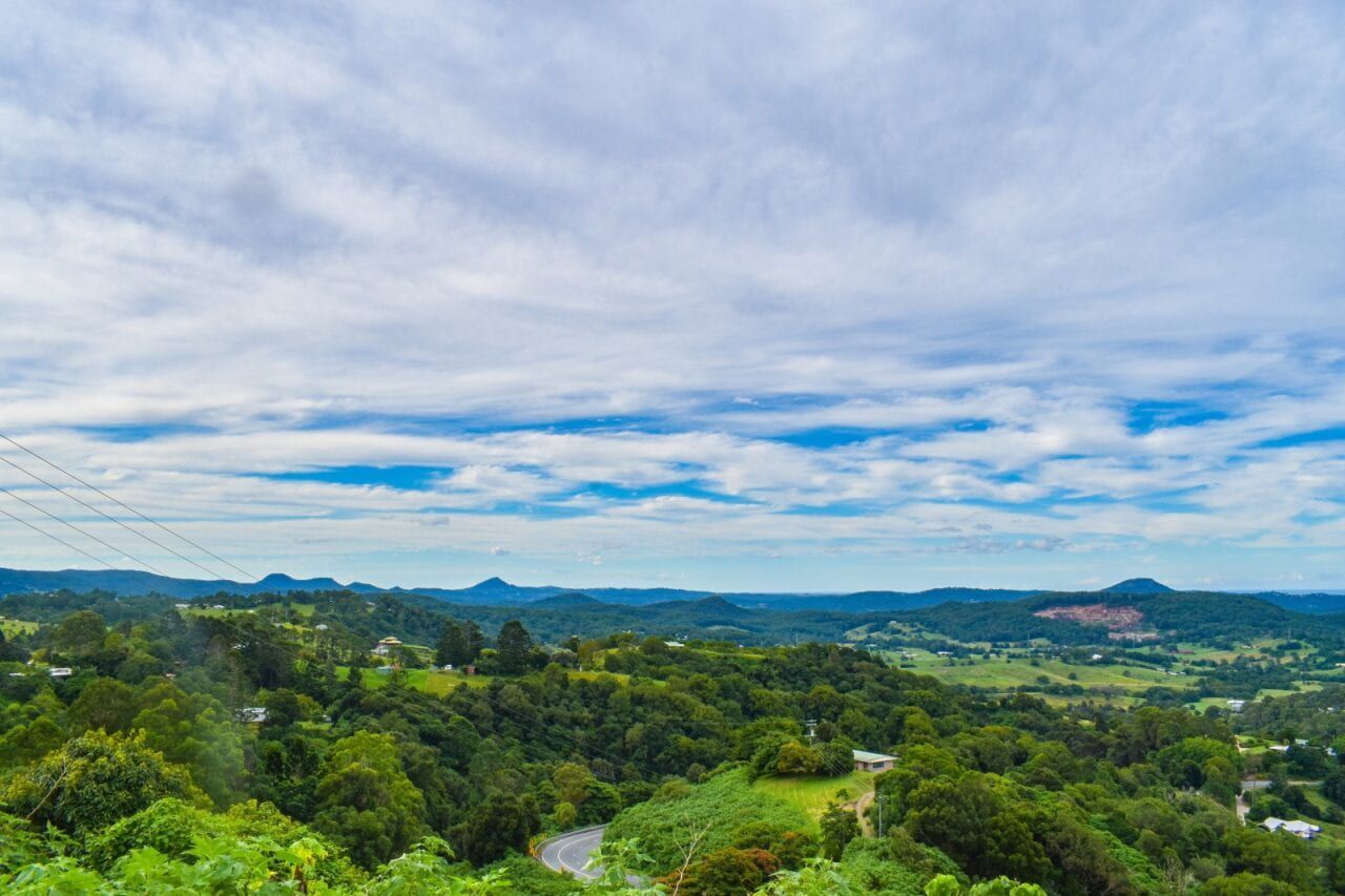 A View of a Lush Green Valley With Mountains in the Background on a Cloudy Day — Whirly Bird King In Mountain Creek, QLD