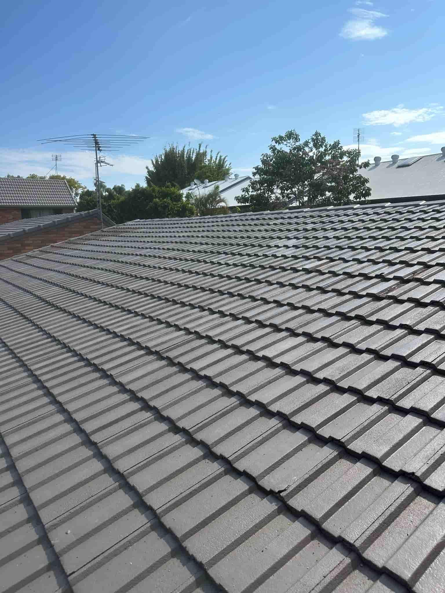 Gray Tiled Roof Under a Blue Sky Rows of Tiles Curve Towards the Top of the Frame — Whirly Bird King in Maroochydore, QLD