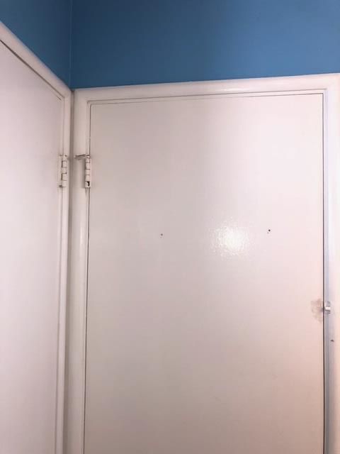 A white door with a blue ceiling in a room.