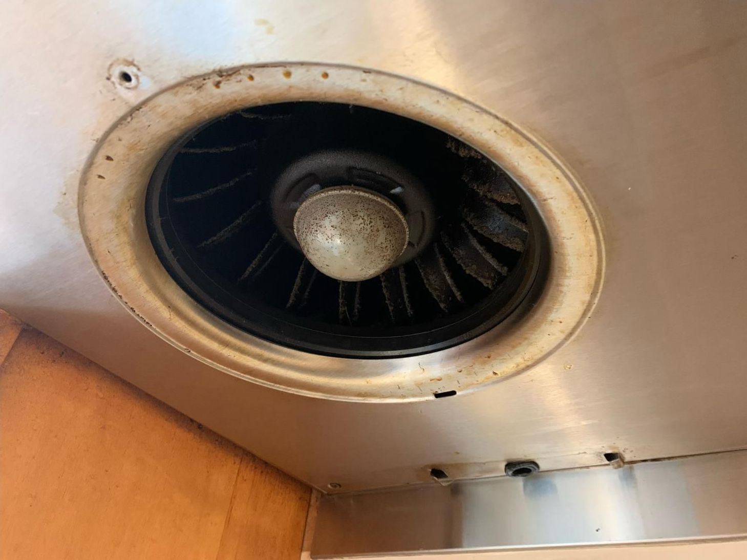 A close up of a stainless steel exhaust fan in a kitchen.