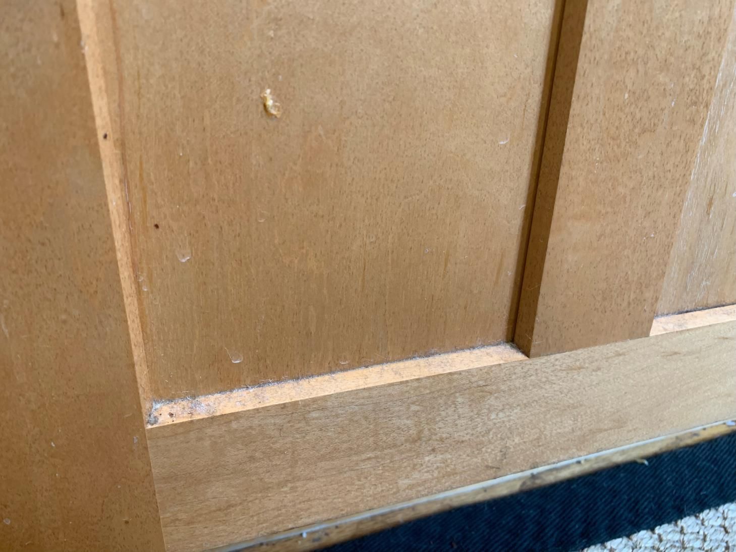 A close up of a wooden door with a screw in it.