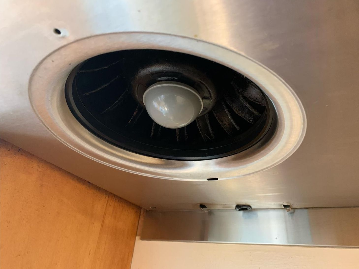 A stainless steel exhaust fan with a light inside of it.