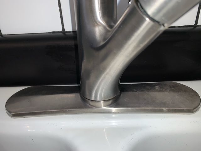 A close up of a stainless steel sink faucet