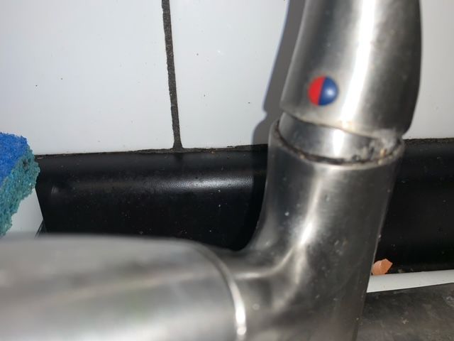 A close up of a faucet with a red and blue button on it.