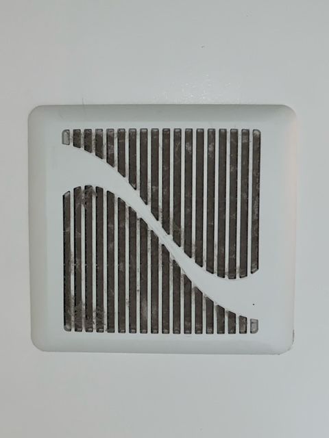 A white wall vent with a striped design on it