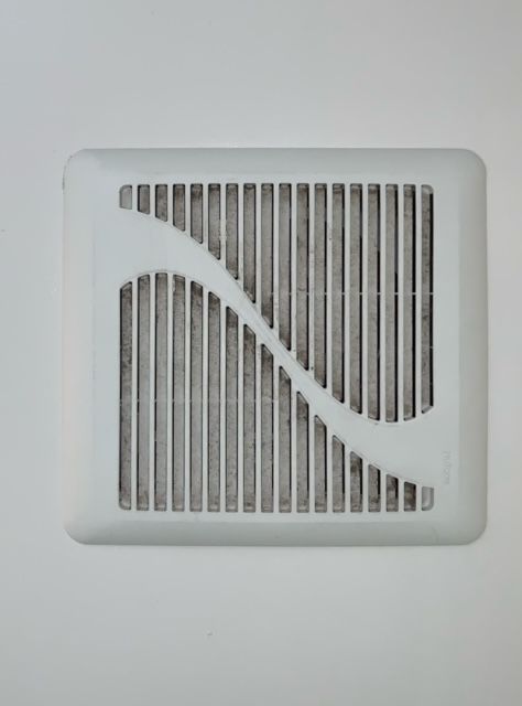 A white square air vent on a white wall.