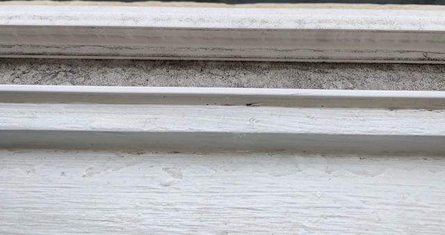 A close up of a window sill on a white wall.