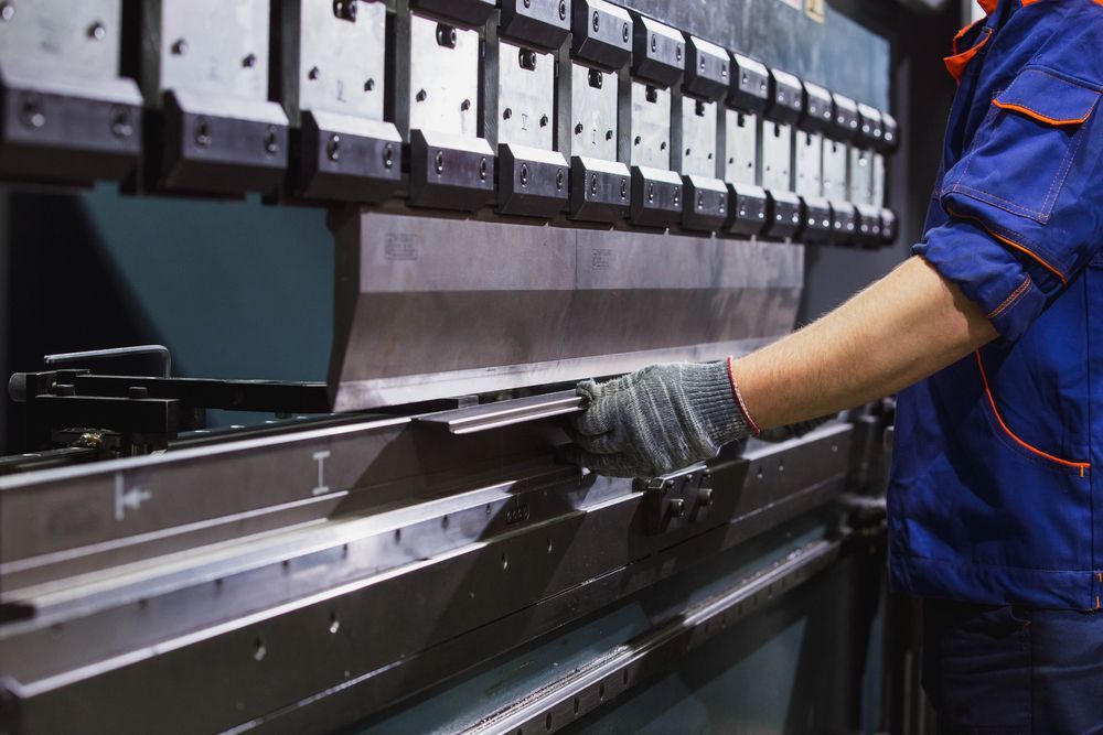 Worker Operating A Machine To Bend Sheet Metal — LM Engineering In Mareeba, QLD