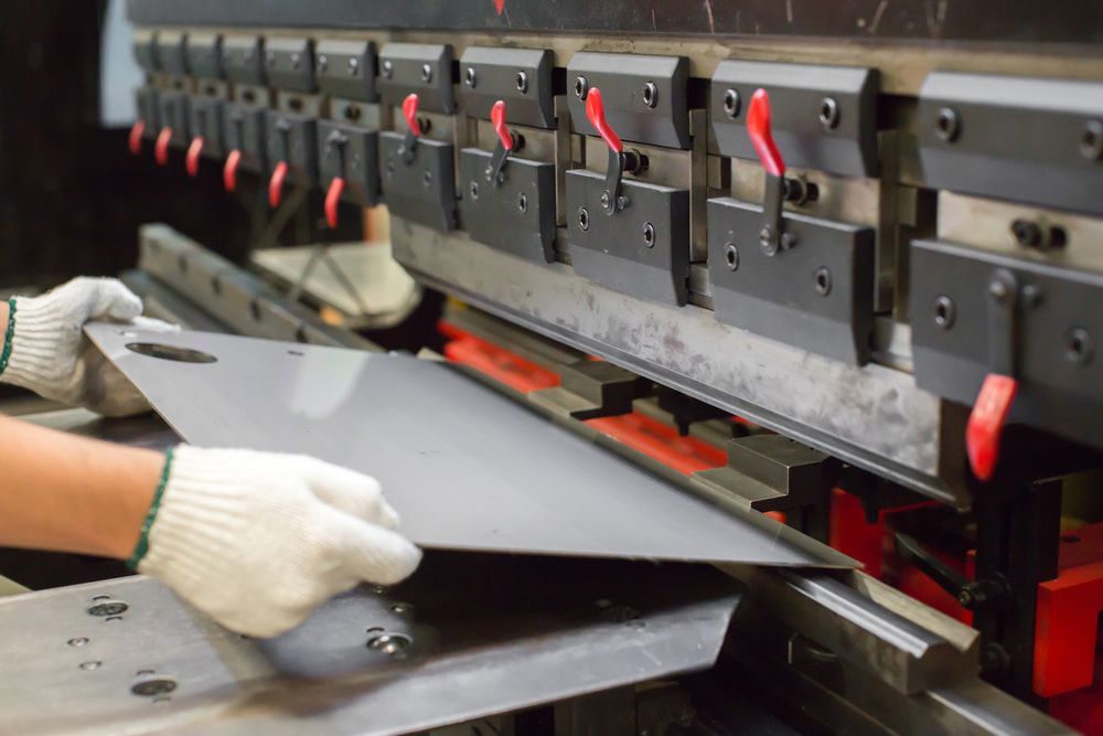 Hands in Gloves Bending a Metal Sheet — LM Engineering in Georgetown, QLD