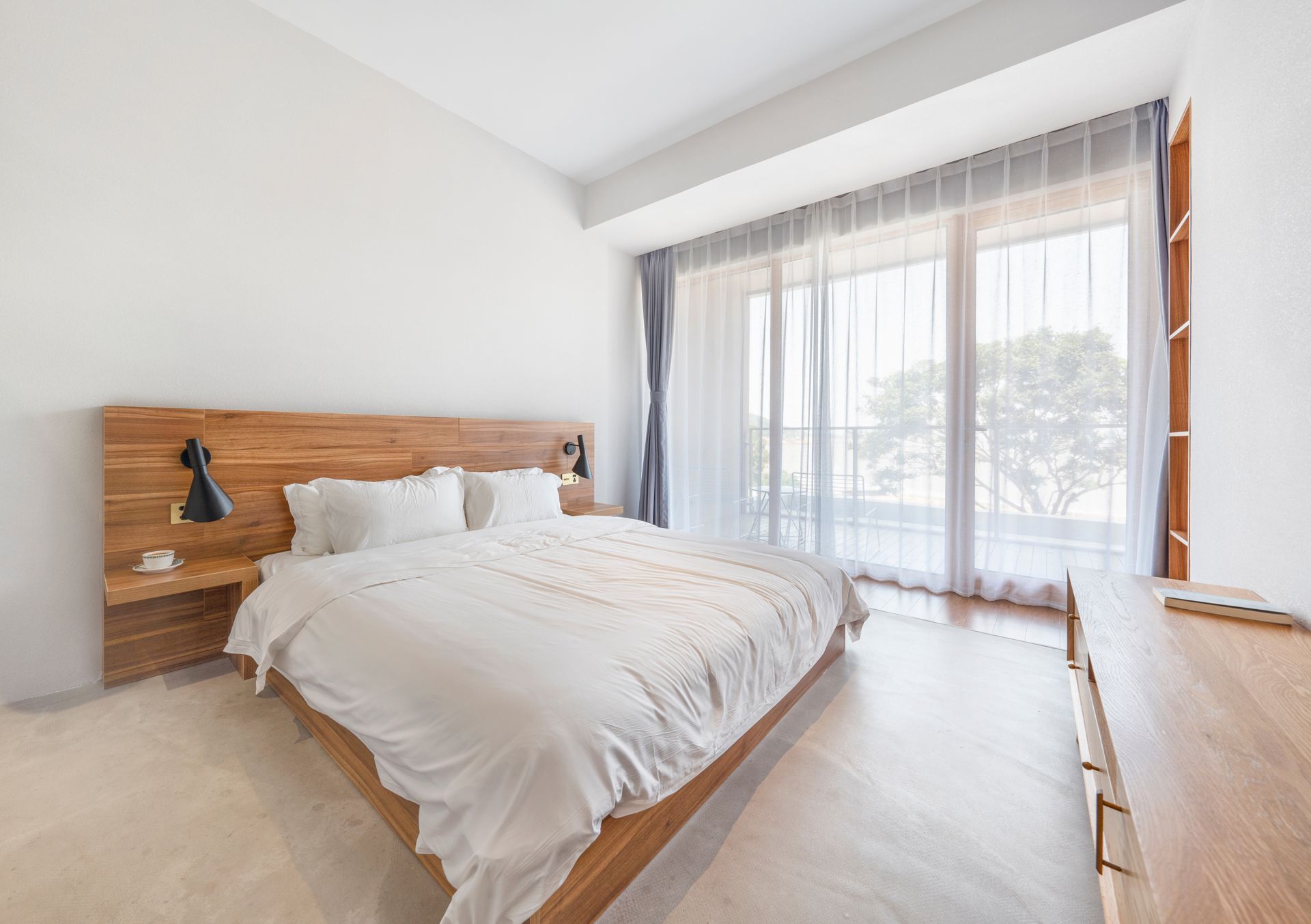 There is a Large Bed in the Middle of the Room With a Large Window