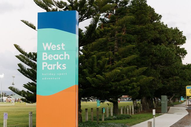 West Beach Parks sign surrounded by trees, near Esplanade Apartments