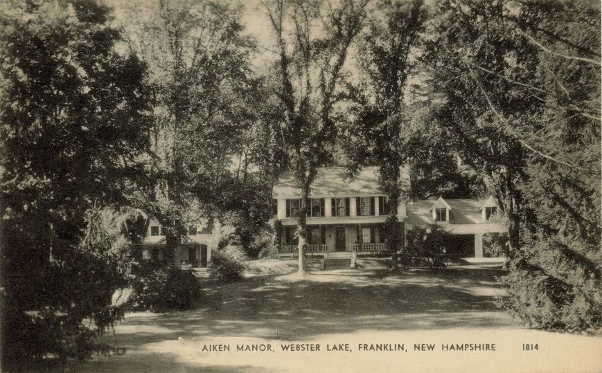a black and white photo of a house with a windmill in the background