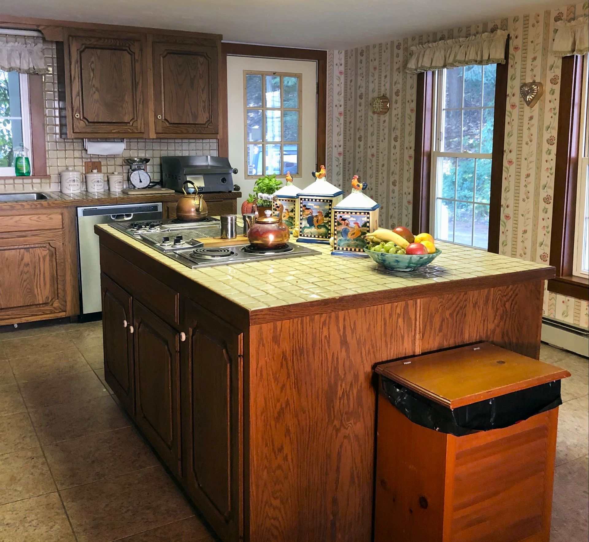 a kitchen with a large island and a trash can