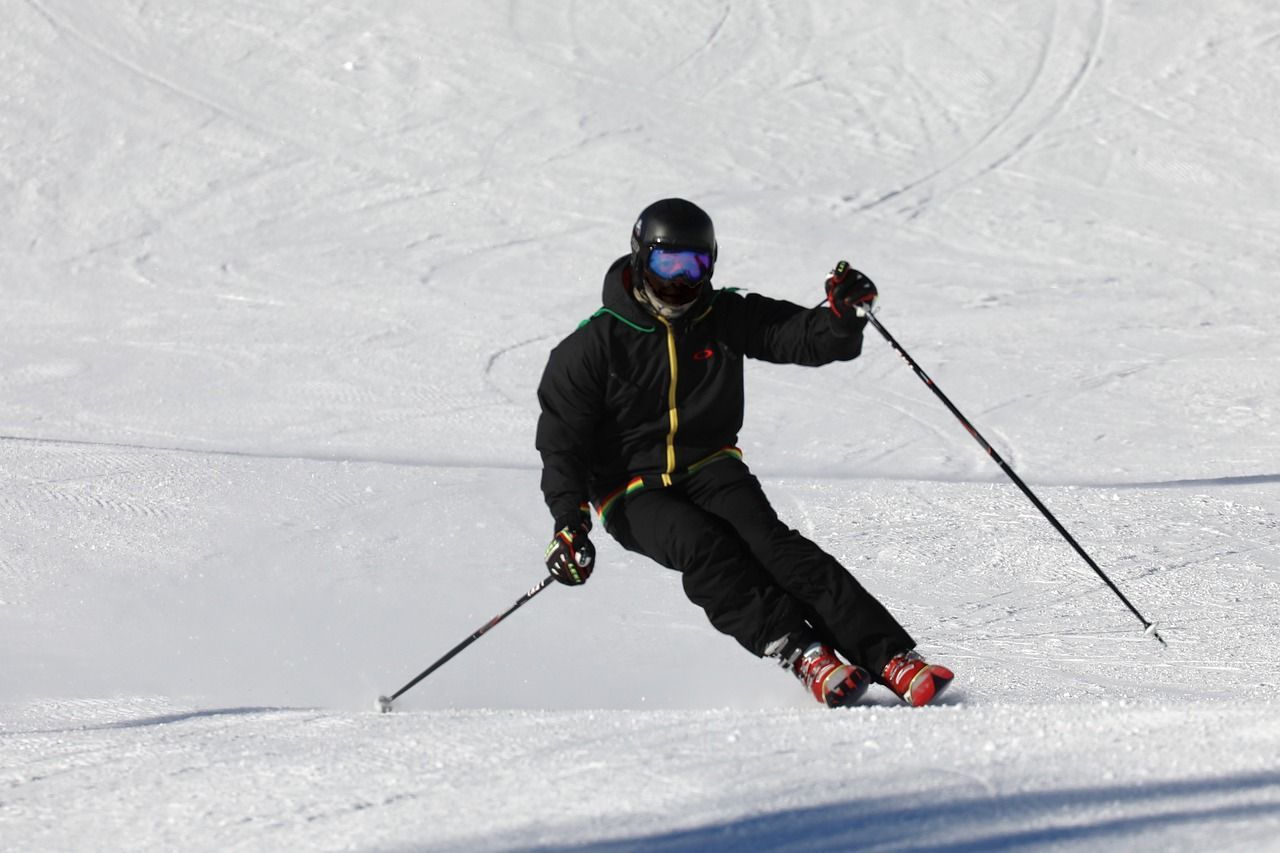 a skier wearing a helmet and goggles is skiing down a snowy slope