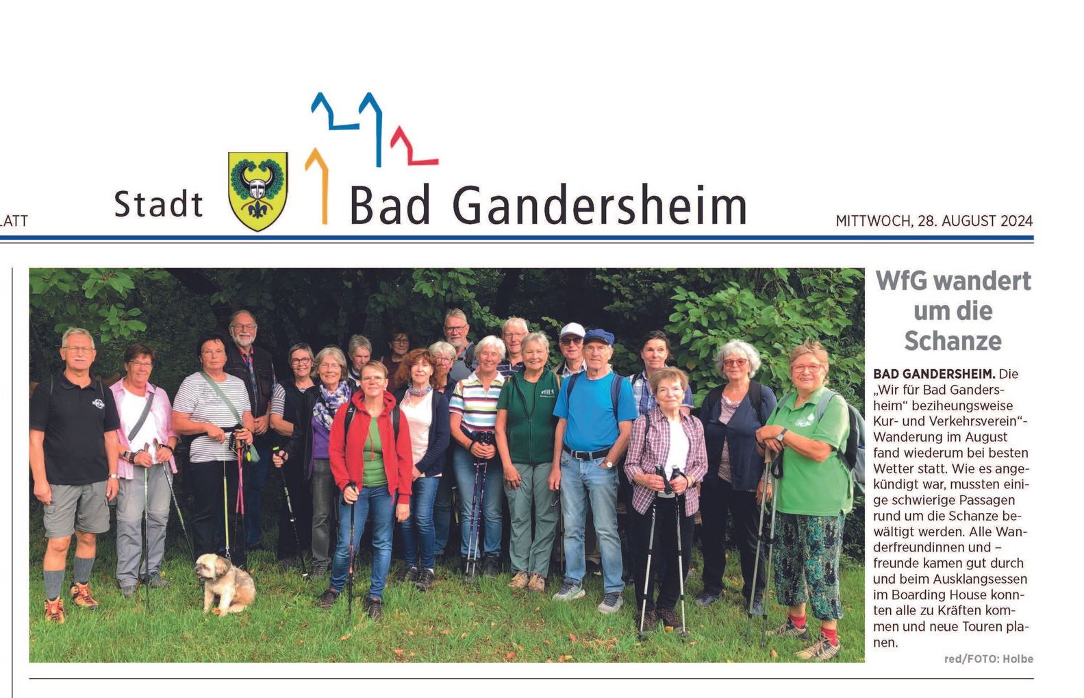 Gruppe von Wanderern mit Stöcken in Bad Gandersheim, in der Nähe des Ortswappens.