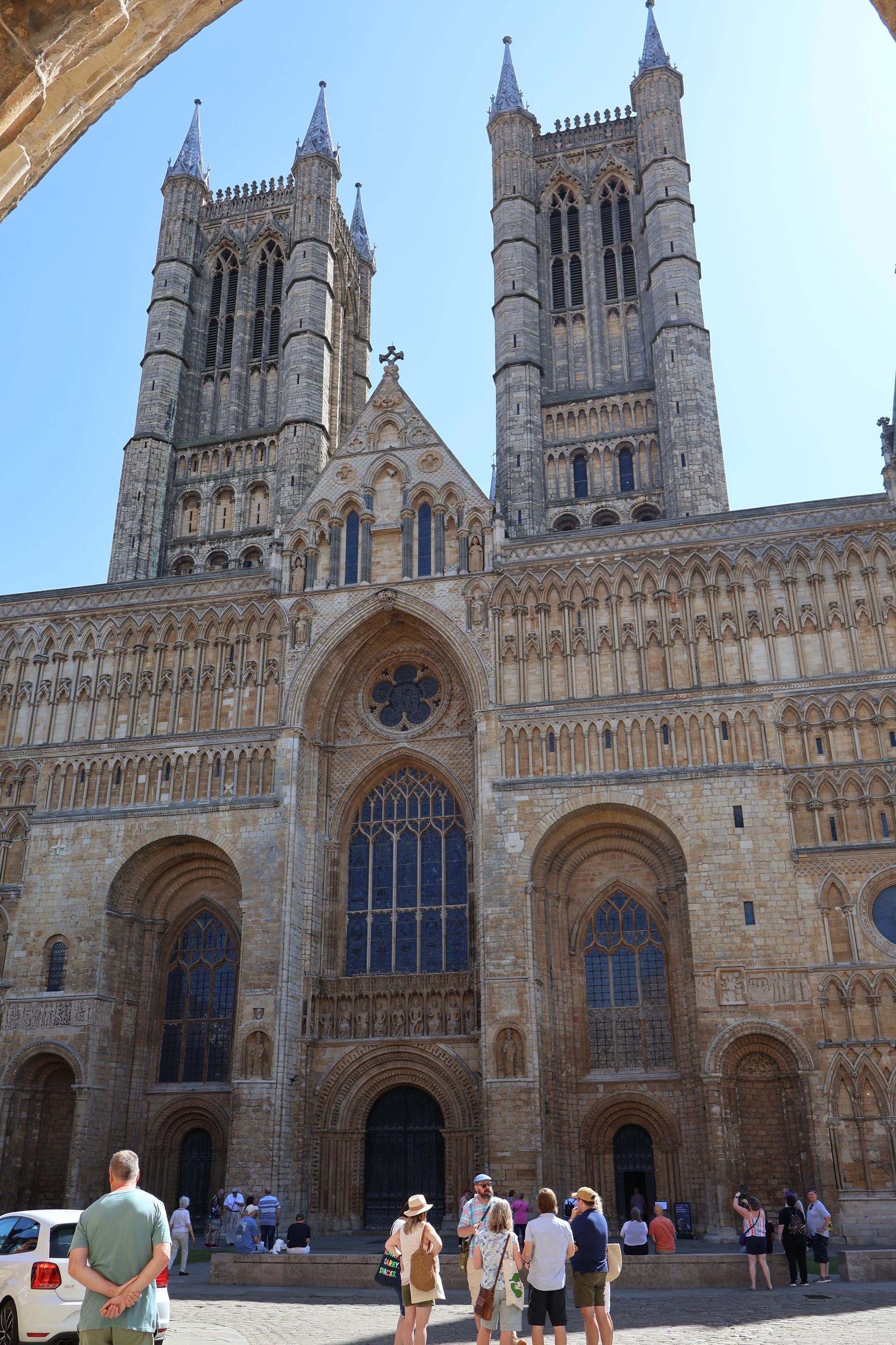 Lincoln Cathedral, eine große gotische Steinkathedrale mit zwei Türmen, vor der sich Menschen versammelt hatten.