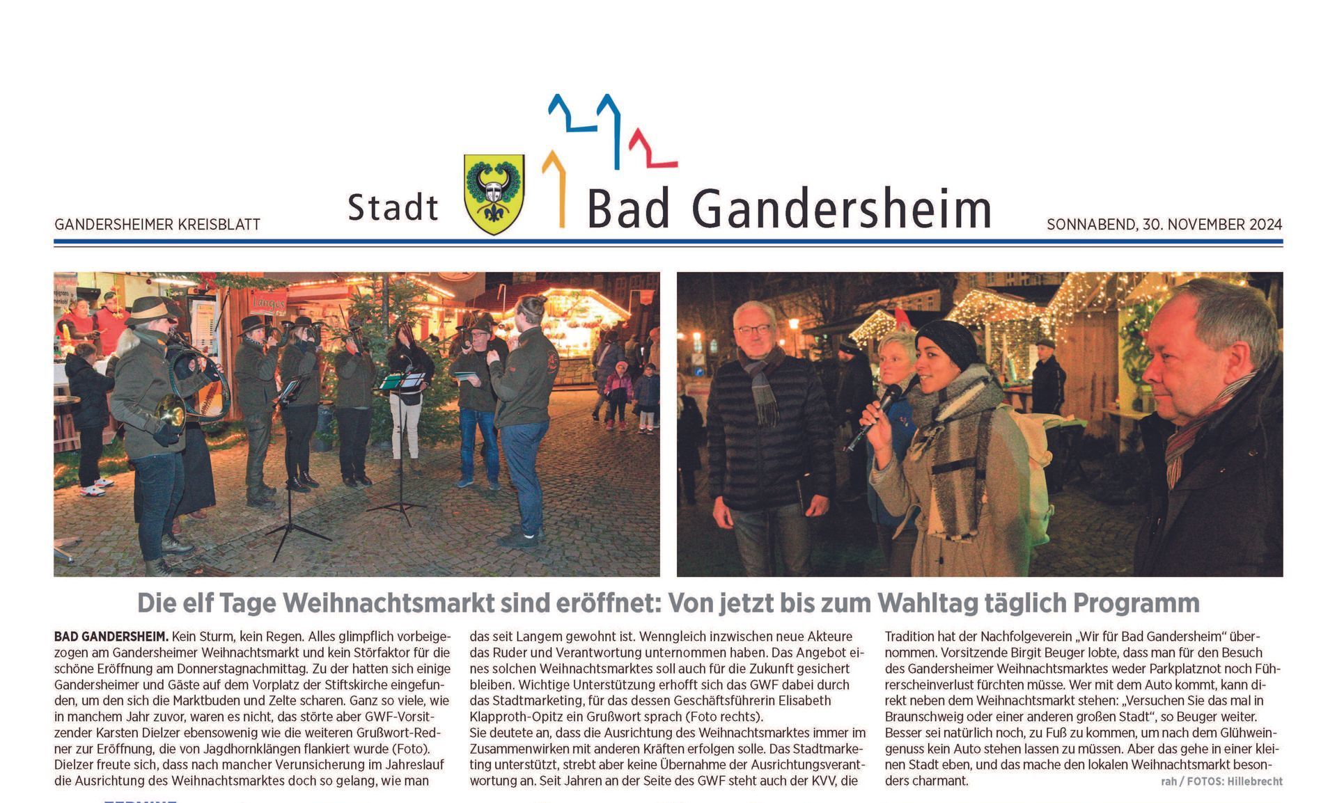 Weihnachtsmarkt in Bad Gandersheim: Eine Kapelle spielt; Menschen unterhalten sich an den beleuchteten Ständen.