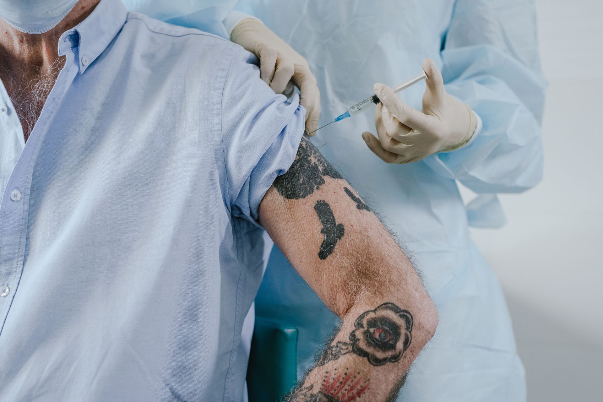 Profissional de saúde aplicando vacina no braço de um homem mais velho