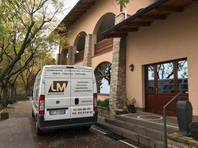 Furgone di LM Sverniciature davanti casa in pietra e legno