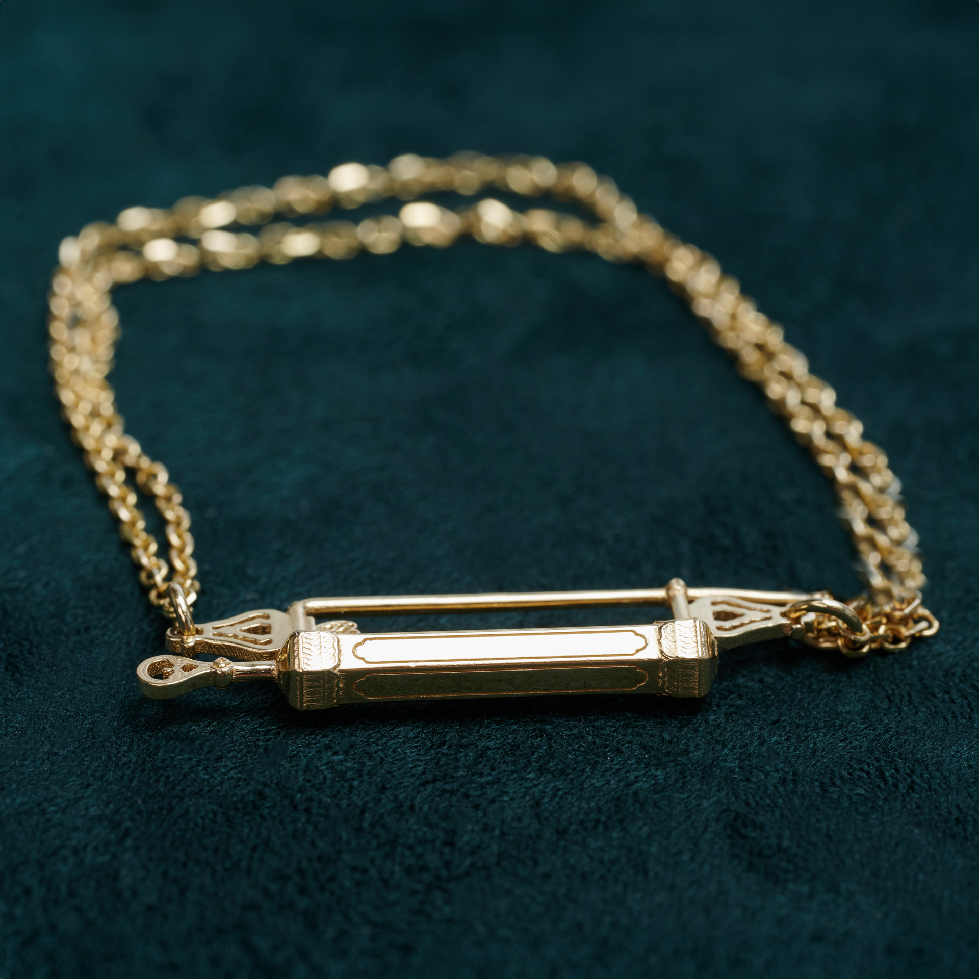 A gold bracelet with a lock on it on a white background.