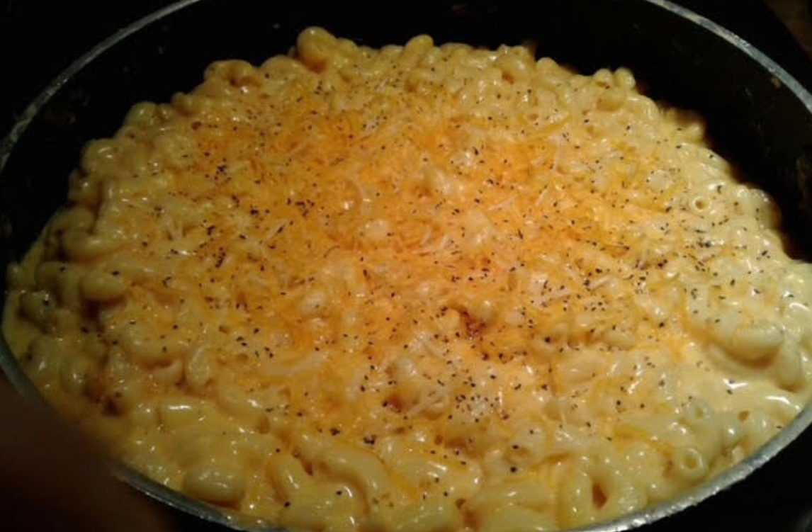 A pan of creamy macaroni and cheese topped with black pepper.
