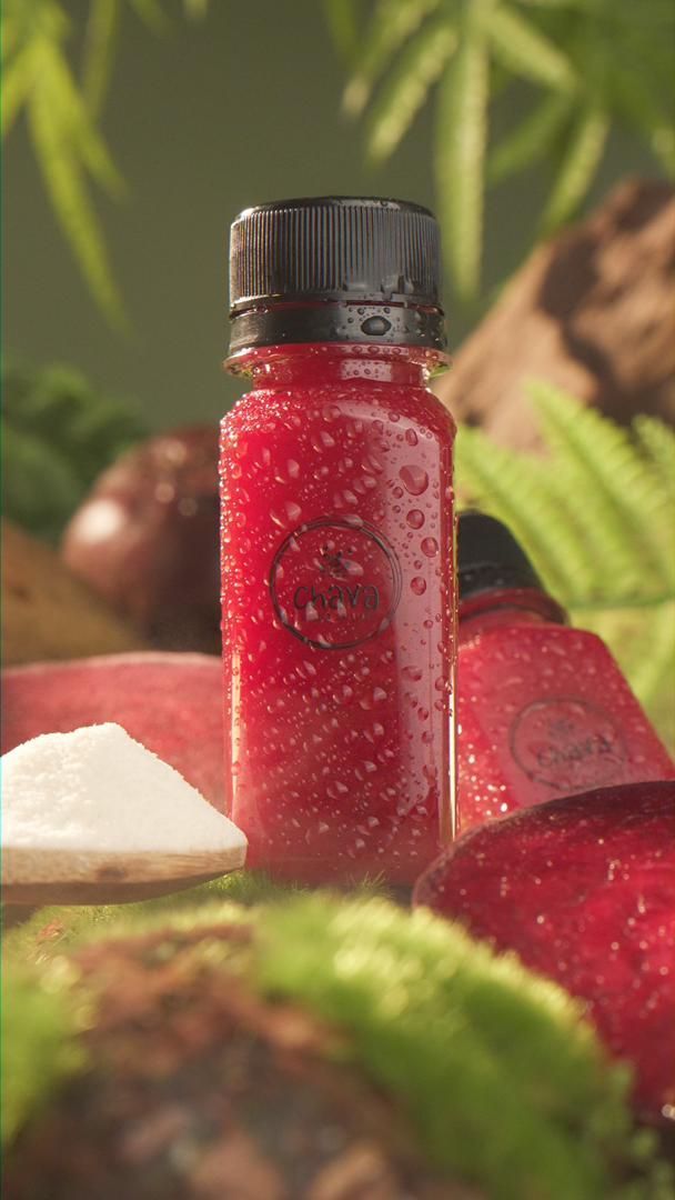 Small red bottle with black cap, surrounded by red fruit, moss, and a white powder.