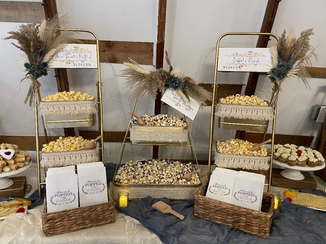 Tiered rustic dessert display with trays of pastries, cookies, and dried floral accents on a stone wall backdrop